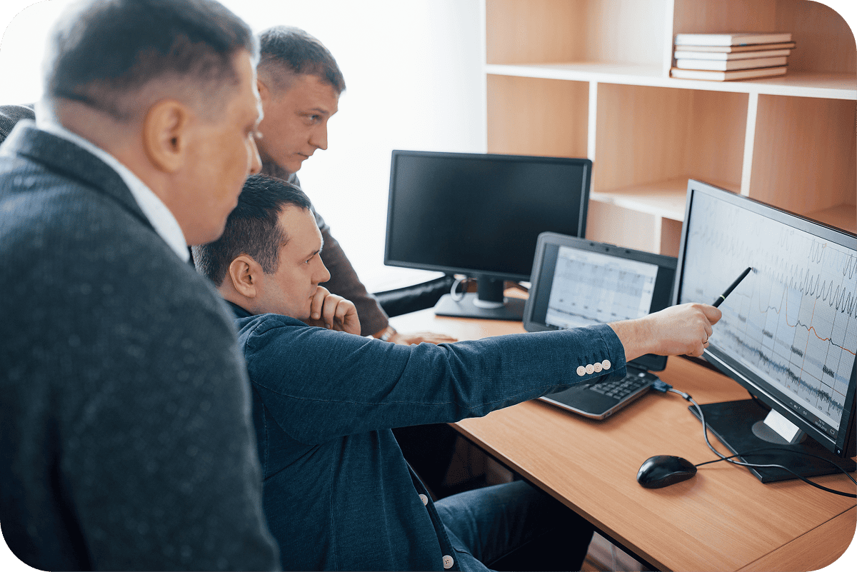 business professionals in a meeting room making quick decisions using a digital dashboard on a large screen